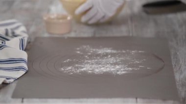 Hamurla çalışan bir kadın. Bir iş yüzeyine maya hamuru koymak.