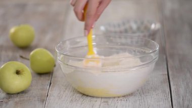 Hamur yapma ve çırpma işlemi, kadınların elleri sıvı hamuru karıştırıyor.