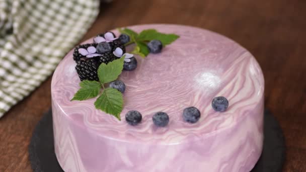 女性の手は、キッチンテーブルの上に新鮮なベリーとベリームースケーキを飾る. — ストック動画