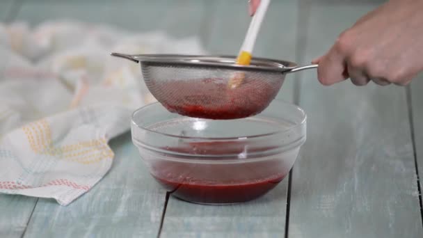 Женщина процеживает ягоды через решето, чтобы сделать пюре. — стоковое видео