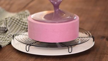 Pastayı kaplayan profesyonel şefe yaklaş. Pastaları aynalı camla süsleyen kadın..