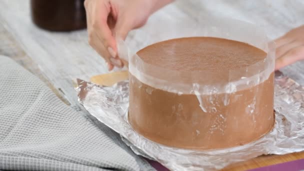 A cukrász eltávolítja az acetát csíkokat a csokoládé habos tortából. — Stock videók