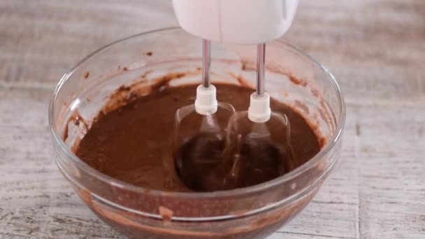 Mischen von Schokoladenteig oder Teig zum Backen von Kuchen, Plätzchen, Gebäck. Mixer schlägt Schokolade in Schüssel. — Stockvideo