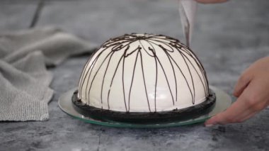 Pastanın üstüne erimiş çikolata dökmek. Çikolata ve fındıklı kremalı panço keki..