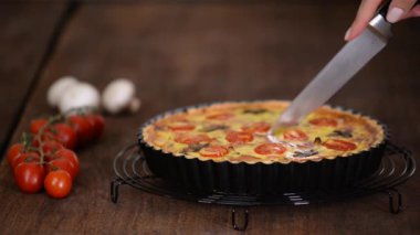 Ev yapımı kiş lorraine 'i tavuk, mantar ve peynirle kesiyorum. Fransız mutfağı..