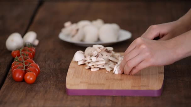 Mulher está cortando cogumelo na mesa da cozinha. — Vídeo de Stock