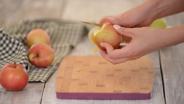 Jonge vrouw schillen appel in keuken. — Stockvideo