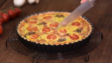 Ev yapımı kiş lorraine 'i tavuk, mantar ve peynirle kesiyorum. Fransız mutfağı..