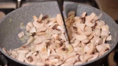 Kızarmış tavuk eti, mantar ve soğan kızartma tavasına yakın..