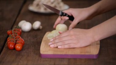 Aşçının elleri bıçakla tahtanın soğanını kesiyor..