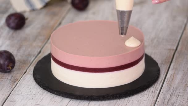 Banketbakker versierde een heerlijke pruimenmuizencake met slagroom. — Stockvideo