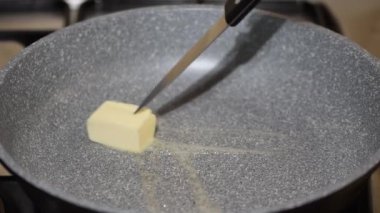 Elektrikli ocakta tereyağını karıştıran kadın, yakın plan..