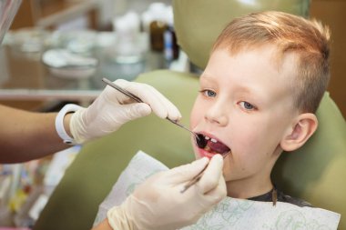 Küçük bir çocuk diş kliniği bir dişçi resepsiyonda. Çocuk Diş Hekimliği, Pediatrik Diş Hekimliği. Bir kadın stomatologis