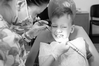 Küçük bir çocuk diş kliniği bir dişçi resepsiyonda. Çocuk Diş Hekimliği, Pediatrik Diş Hekimliği. Blac ve beyaz retro tarzı fotoğraf. Ağız sağlığı ve hijyen