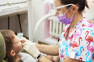 Küçük bir çocuk diş kliniği bir dişçi resepsiyonda. Çocuk Diş Hekimliği, Pediatrik Diş Hekimliği. Bir kadın stomatologis