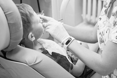 Küçük bir çocuk diş kliniği bir dişçi resepsiyonda. Çocuk Diş Hekimliği, Pediatrik Diş Hekimliği. Blac ve beyaz retro tarzı fotoğraf. Ağız sağlığı ve hijyen