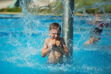 Mavi su havuz tropikal bir çare olarak denizin üzerinde oynayan mutlu çocuk. Yaz tatil kavramı. Sevimli çocuk havuzu suda yüzmek. Sıçramasına ve having fun yüzme havuzunda çocuk