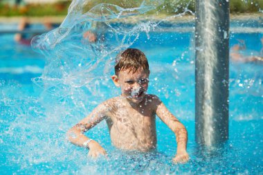 Mavi su havuz tropikal bir çare olarak denizin üzerinde oynayan mutlu çocuk. Yaz tatil kavramı. Sevimli çocuk havuzu suda yüzmek. Sıçramasına ve having fun yüzme havuzunda çocuk