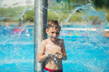 Mavi su havuz tropikal bir çare olarak denizin üzerinde oynayan mutlu çocuk. Yaz tatil kavramı. Sevimli çocuk havuzu suda yüzmek. Sıçramasına ve having fun yüzme havuzunda çocuk