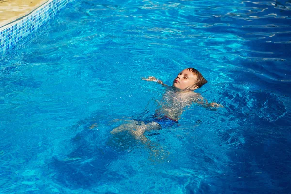 快乐的孩子玩在游泳池上一个热带度假胜地在海蓝色的水中 夏季度假概念 可爱的男孩在泳池里的水中游泳 溅和乐趣在游泳池里的孩子 — 图库照片