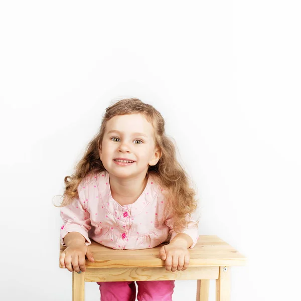 可爱的小孩子坐在椅子上 微笑着 穿着粉红色的衣服 白色背景下可爱的女婴肖像 — 图库照片
