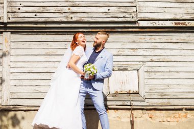 Sadece evli sevgi dolu hipster çift düğün giysi ve eski bir ahşap evin önünde poz takım. Mutlu gelin ve damat yürüyüş koşma ve dans. Romantik evli genç aile. Sonbahar düğün