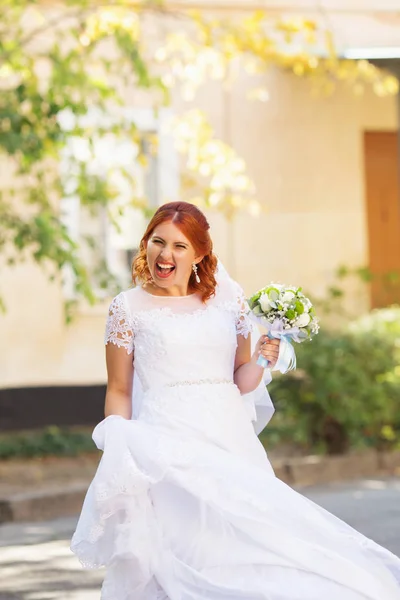 屋外の花束と赤毛の美しい花嫁 幸せな花嫁のジャンプと楽しいアウトドア 彼女の結婚式の日でポーズ美しい花嫁 — ストック写真