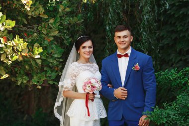 Sadece evli sevgi dolu hipster çift düğün giysi ve parkta takım. Mutlu gelin ve damat güzel bahçede yürüyüş. Romantik evli genç aile. Düğün yaz