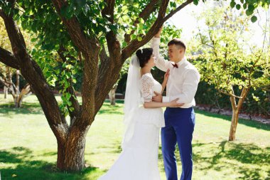 Sadece evli sevgi dolu hipster çift düğün giysi ve parkta takım. Mutlu gelin ve damat güzel bahçede yürüyüş. Romantik evli genç aile. Düğün yaz