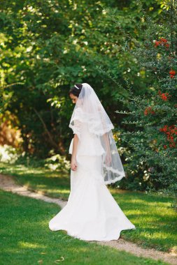 Güzel esmer gelin buketi açık ile. Mutlu gelin açık havada. Güzel gelin düğün gününde poz