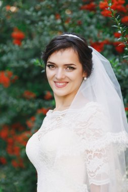 Güzel esmer gelin buketi açık ile. Mutlu gelin açık havada. Güzel gelin düğün gününde poz