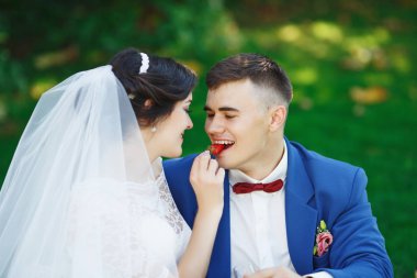 Sadece evli sevgi dolu hipster çift düğün giysi ve parkta takım. Mutlu gelin ve damat güzel bahçede yürüyüş. Romantik evli genç aile. Düğün yaz