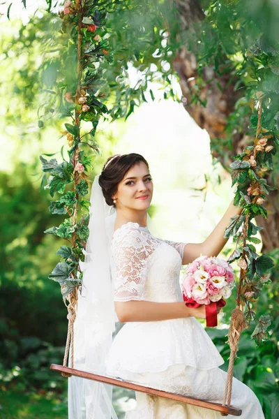 屋外の花束と美しいブルネットの花嫁 幸せな花嫁の屋外 彼女の結婚式の日でポーズ美しい花嫁 — ストック写真