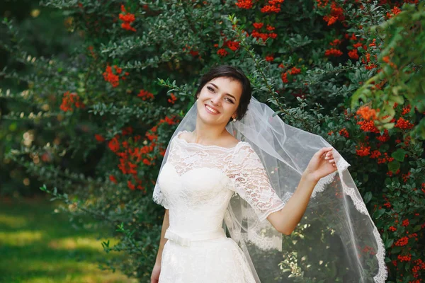 屋外の花束と美しいブルネットの花嫁 幸せな花嫁の屋外 彼女の結婚式の日でポーズ美しい花嫁 — ストック写真