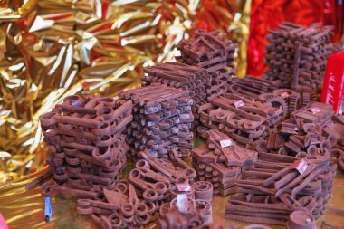 Close up of Christmas market stall in Vienna, Austria. Various tools made of chocolate. reproduction in milk chocolate, screws and bolts. chocolate candies in the form of old rusty metal locksmith tools clipart
