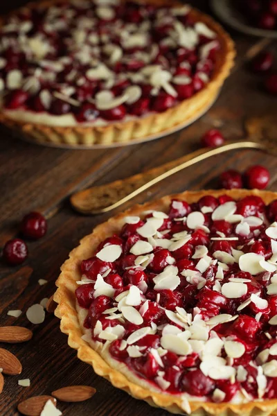 Beautiful freshly made cherry tart decorated with almond chips. Stunning cherry pie still life composition. Food photography. Process of making tart.