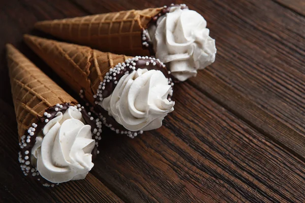 ice cream cones on wooden table. Soft ice creams or frozen custard in cones. Waffle marshmallow imitating ice cream