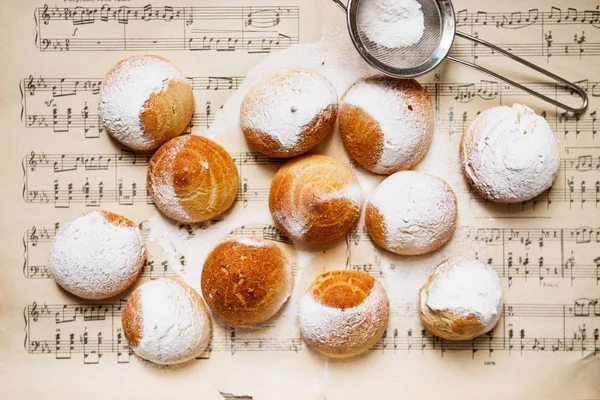 Domácí věnečky na hudbu listu s poznámkami. Profiterole — Stock fotografie