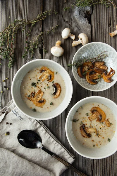 Two bowls with delicious mushroom soup on wooden table — Stock Image Two bowls with delicious mushroom soup on wooden table Royalty Free Stock Photos