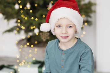 Noel Baba şapkalı küçük bir çocuk. Noel'de güzel çocuk portresi 