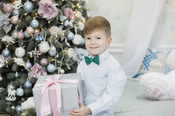 Glücklicher kleiner Junge mit Weihnachtsgeschenk. Junge freut sich über Geschenk. c — Stockfoto