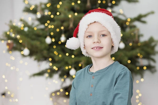 Ragazzino col cappello da Babbo Natale. Ritratto di bel bambino a Natale — Foto Stock