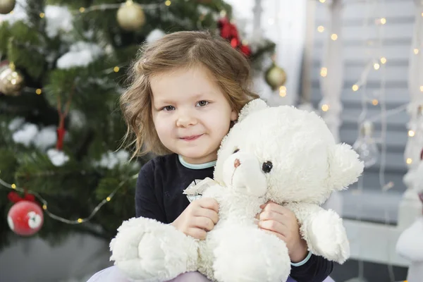 Retrato de una linda niña abrazando a un oso de peluche suave — Foto de Stock