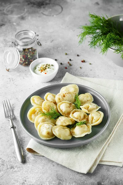 Gehakt dumplings-Russische pelmeni, ravioli met vlees op een grijze pl — Stockfoto