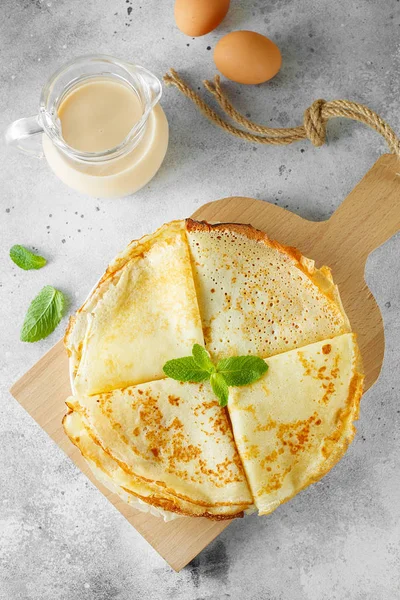 Russiske pandekager serveret med mynteblade og ingredienser mælk - Stock-foto