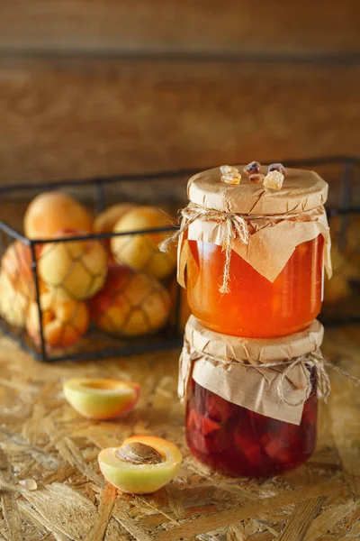 Mermelada de albaricoque sobre un fondo rústico de madera. Dos frascos de fruta hom — Foto de Stock