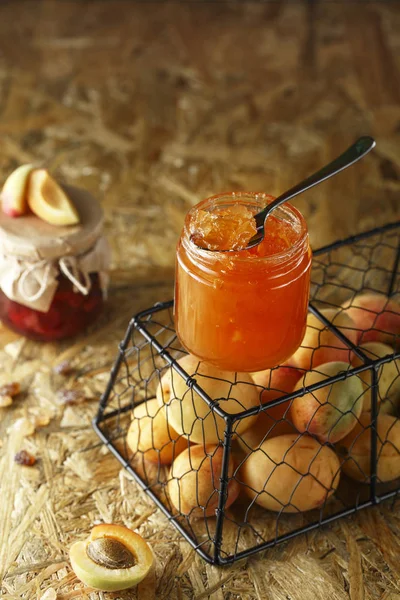 Confiture d'abricot sur un fond rustique en bois. Deux pots de fruits hom — Photo