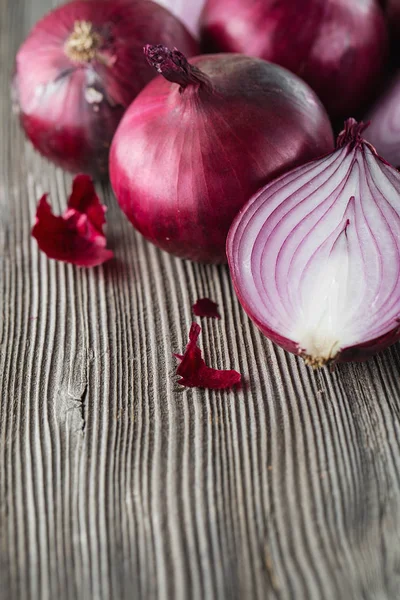 Rote Zwiebeln auf rustikalem Holz. rote Zwiebelhälften. Lebensmittelzutaten — Stockfoto