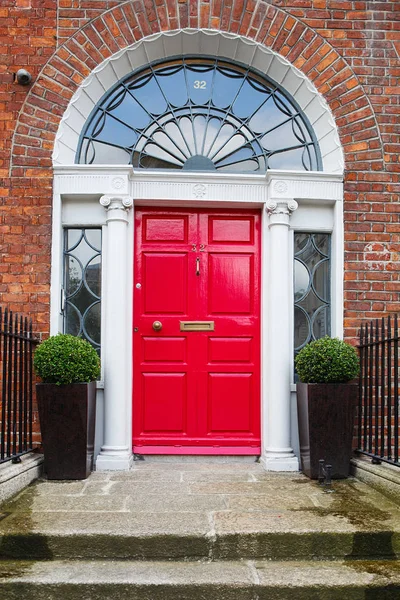 Una puerta roja en Dublín, Irlanda. Puerta georgiana arqueada frente a la casa — Foto de Stock