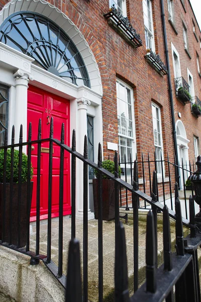 Una puerta roja en Dublín, Irlanda. Puerta georgiana arqueada frente a la casa — Foto de Stock